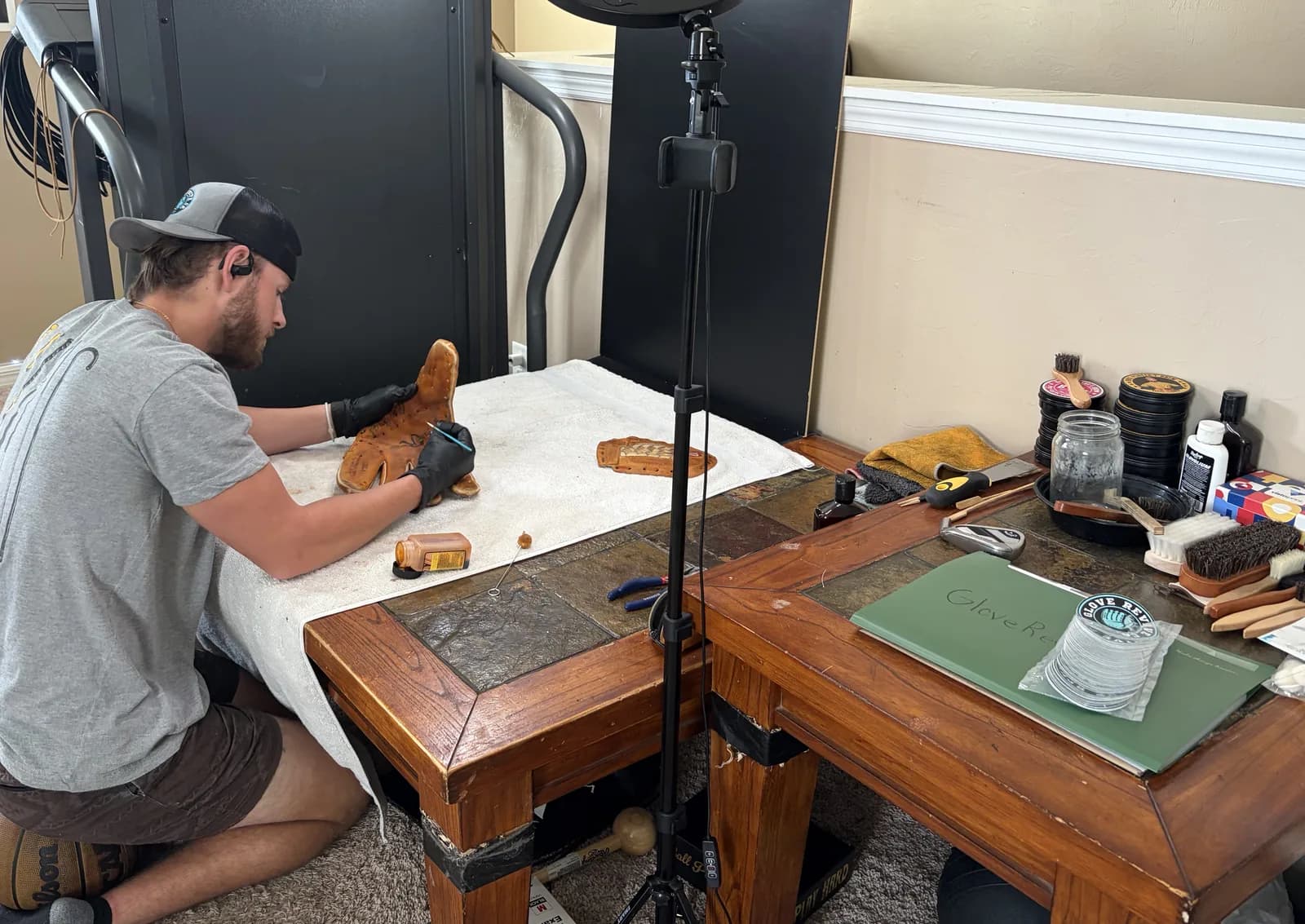 Paul Martin relacing a glove at his workbench